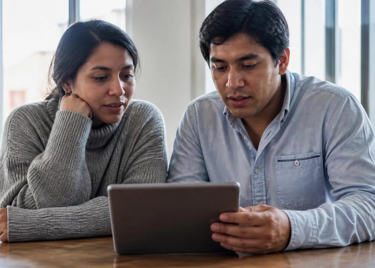 Dos personas inclinadas sobre una tablet con anotaciones